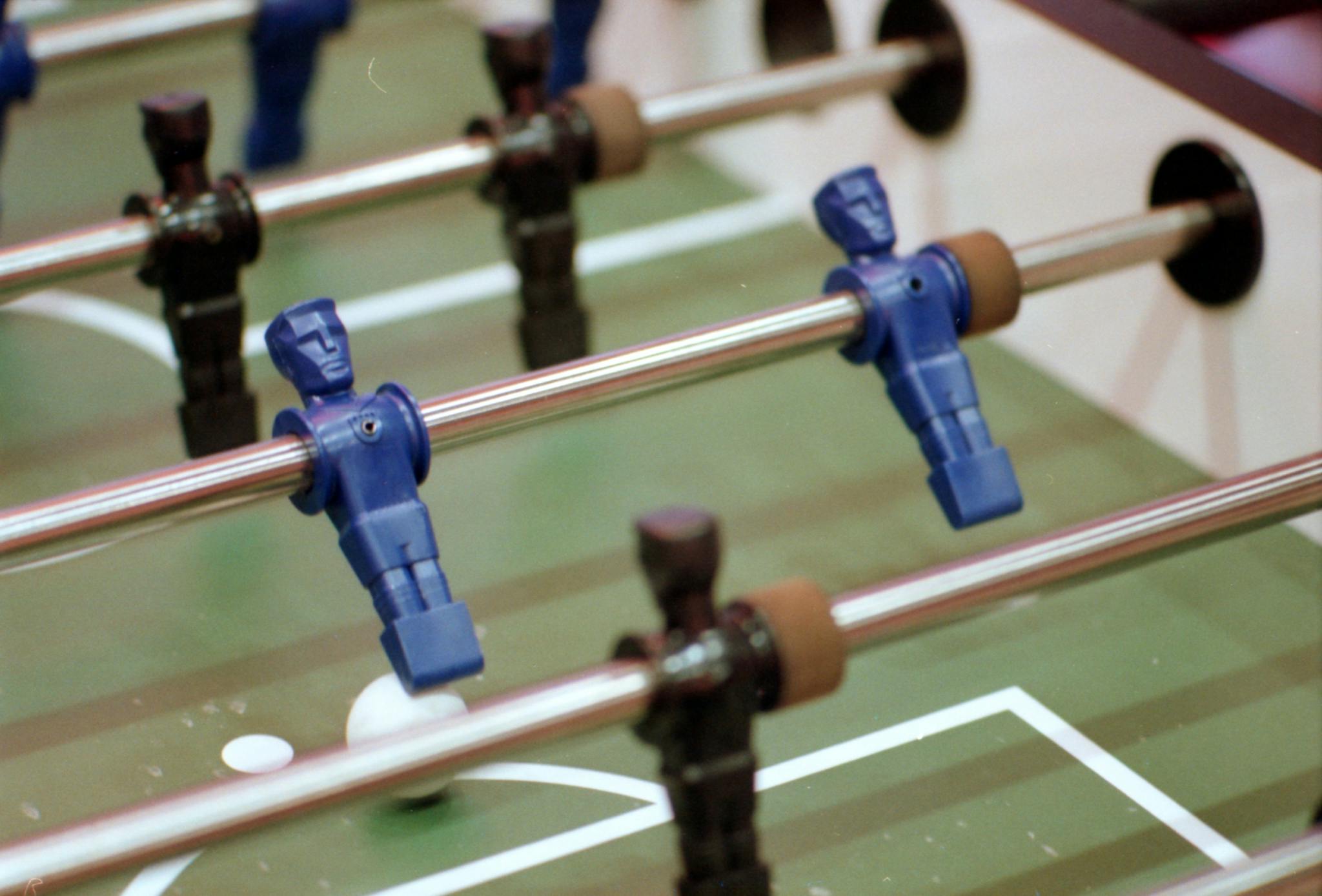 Detailed view of foosball table players in motion during a game.